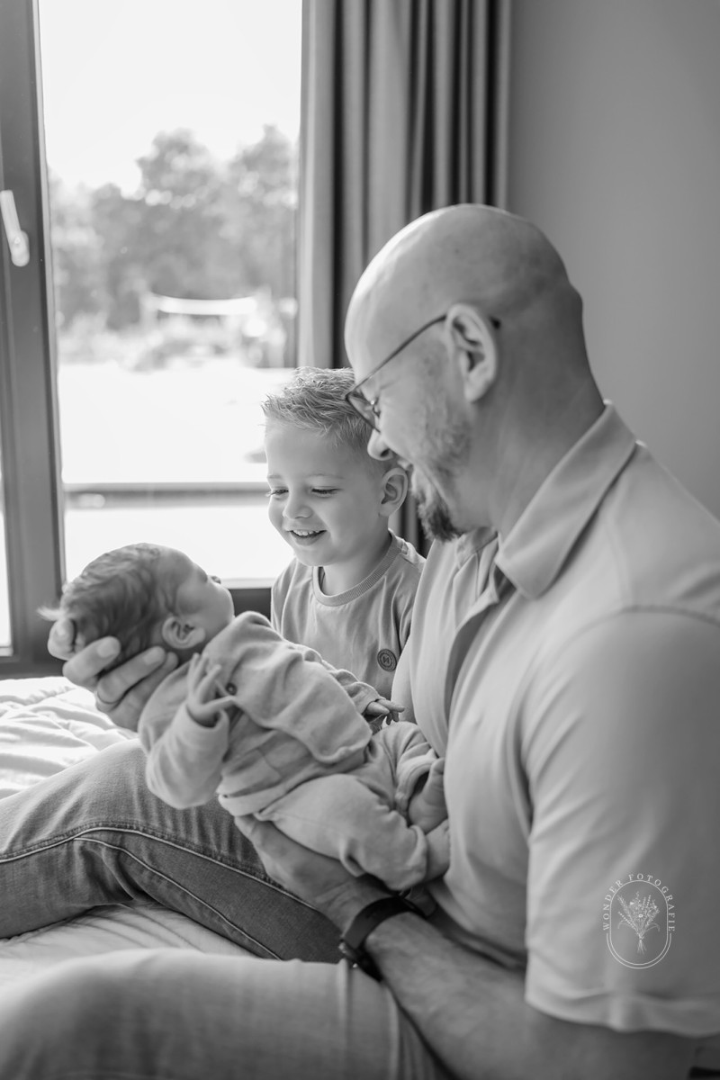 Pasgeboren baby samen met zijn grote broer tijdens een newborn fotoshoot