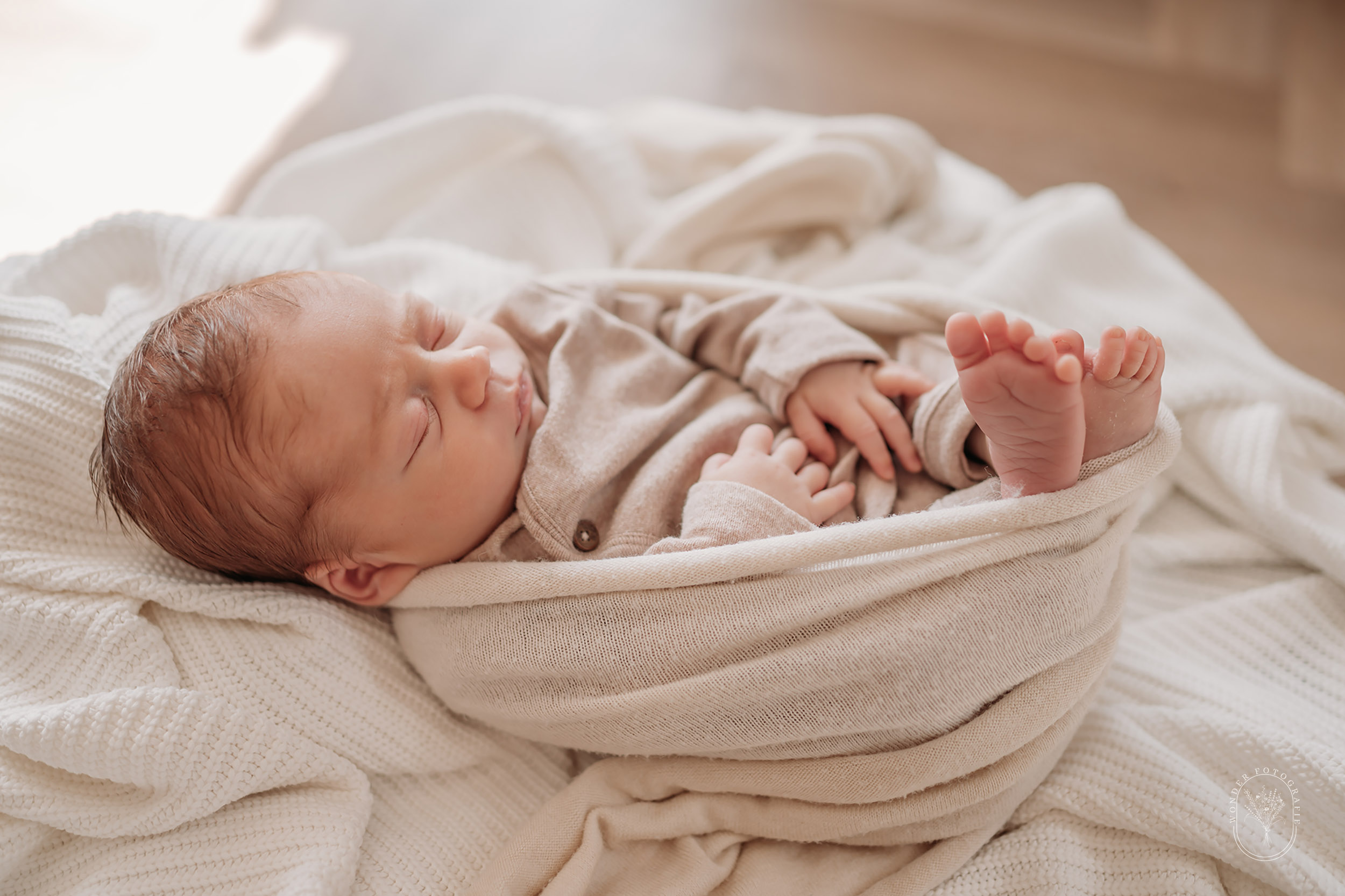 	Gestylde newbornfoto in Wolvega van een baby op een zacht kussen met doeken