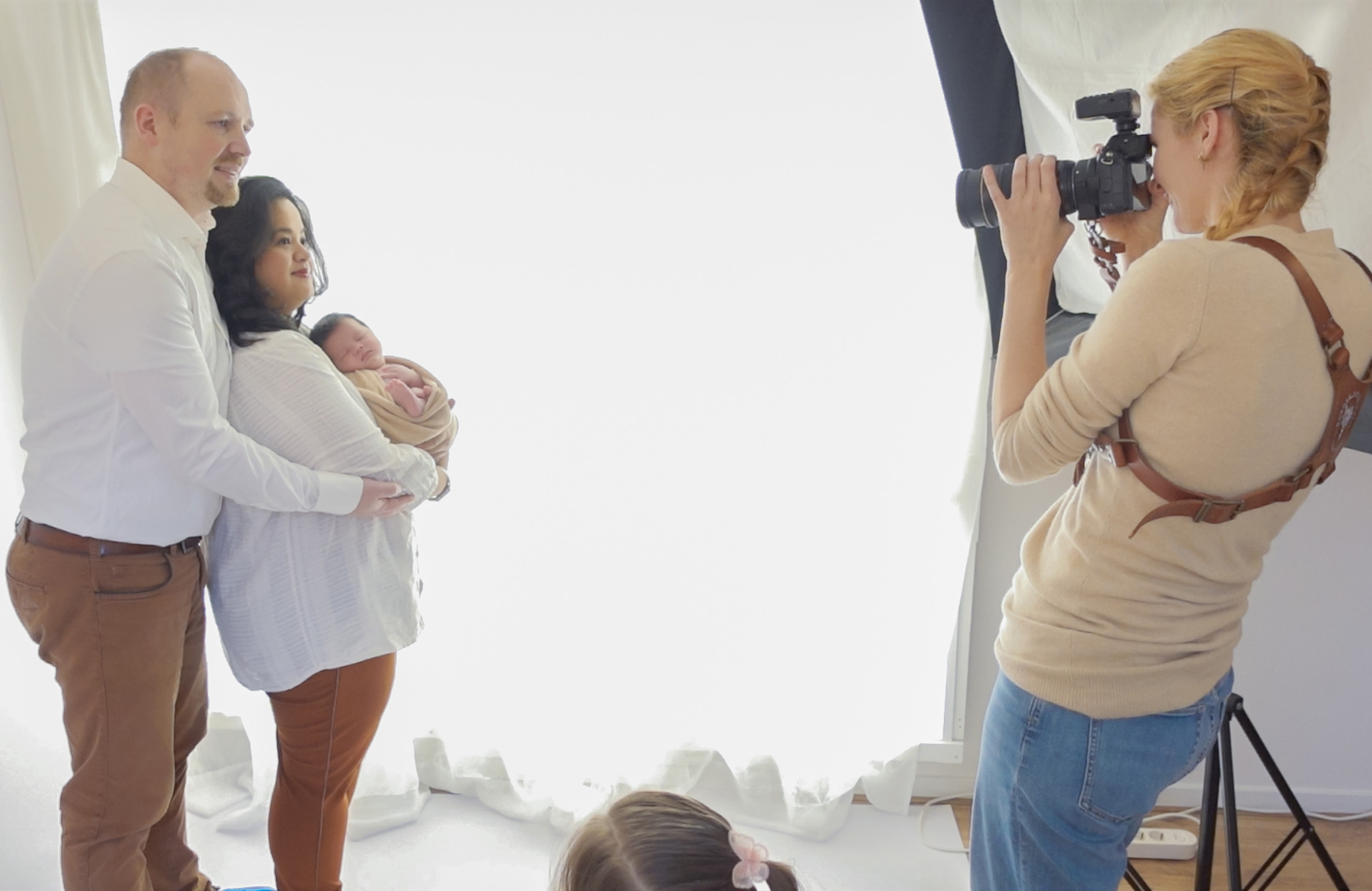 Pasgeboren baby samen met de ouders tijdens de fotoshoot