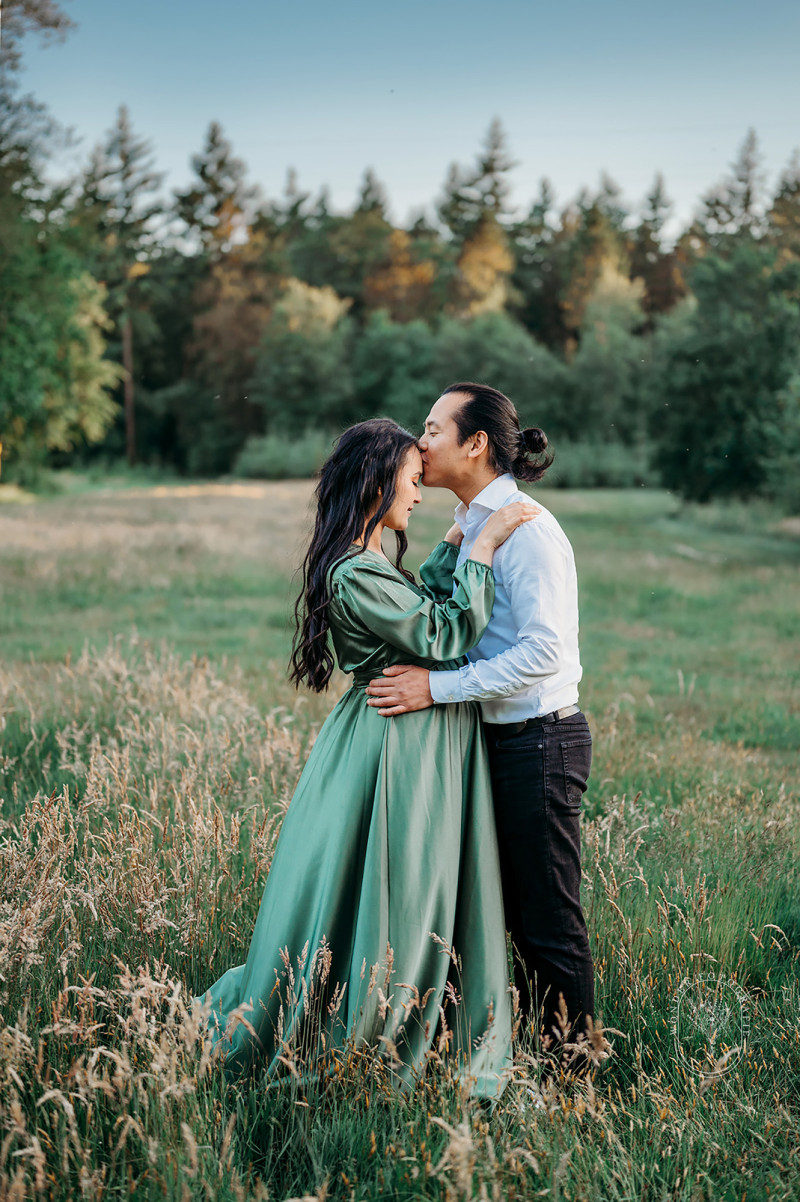 Romantisch moment tussen partners tijdens zwangerschapsfotoshoot in natuur